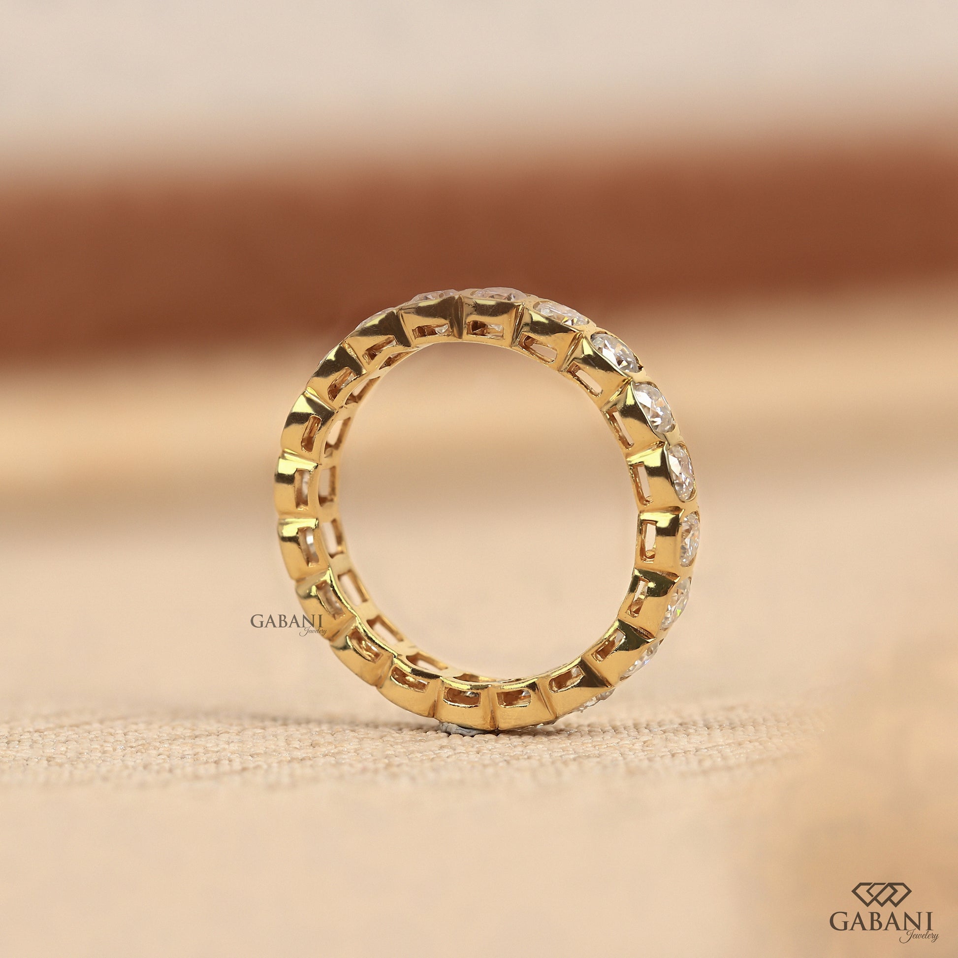 Modern bezel set eternity band featuring cushion cut lab created diamonds in polished metal