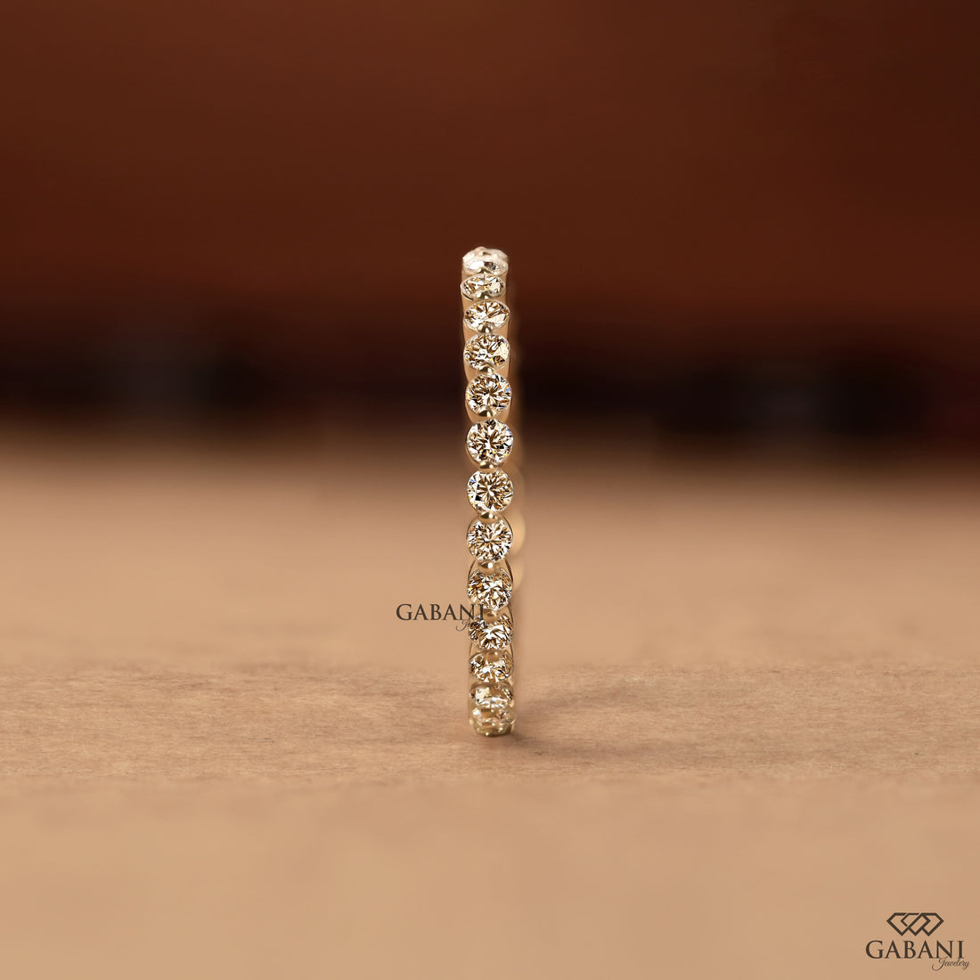 Round cut lab grown diamond bezel set eternity wedding band in solid yellow gold, stackable bridal and anniversary ring.