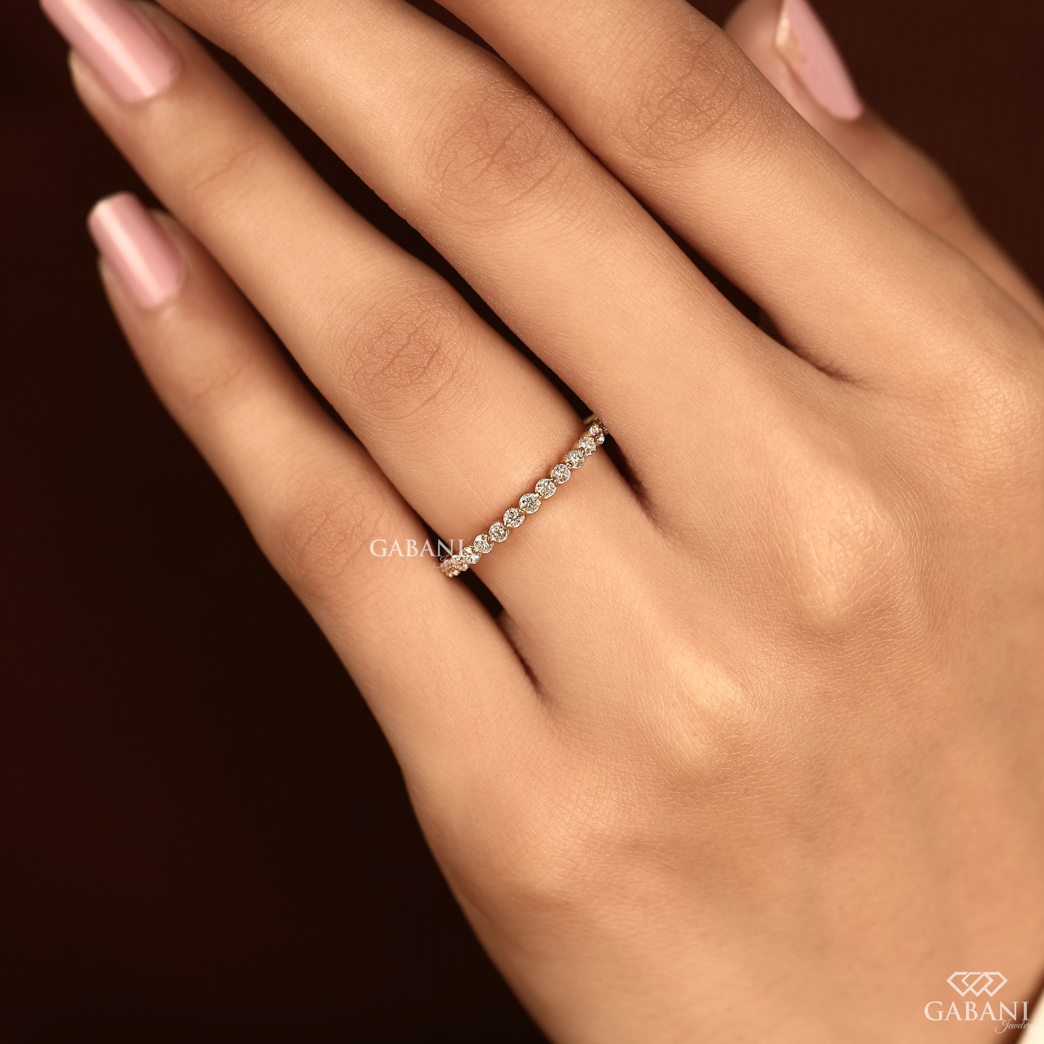 Round cut lab grown diamond bezel set eternity wedding band in solid yellow gold, stackable bridal and anniversary ring.