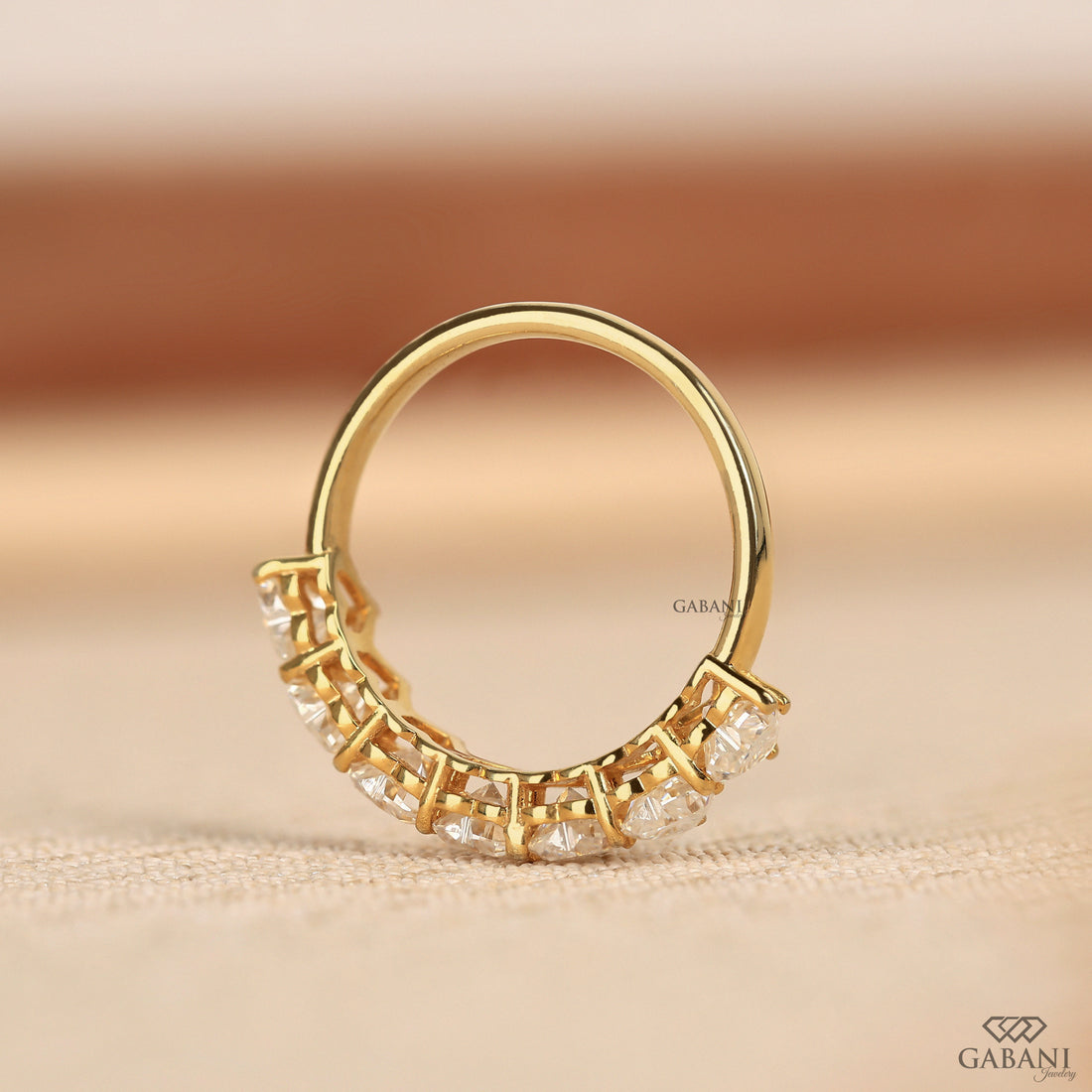 seven heart cut lab grown diamonds in a yellow gold half eternity wedding band with delicate prong settings.