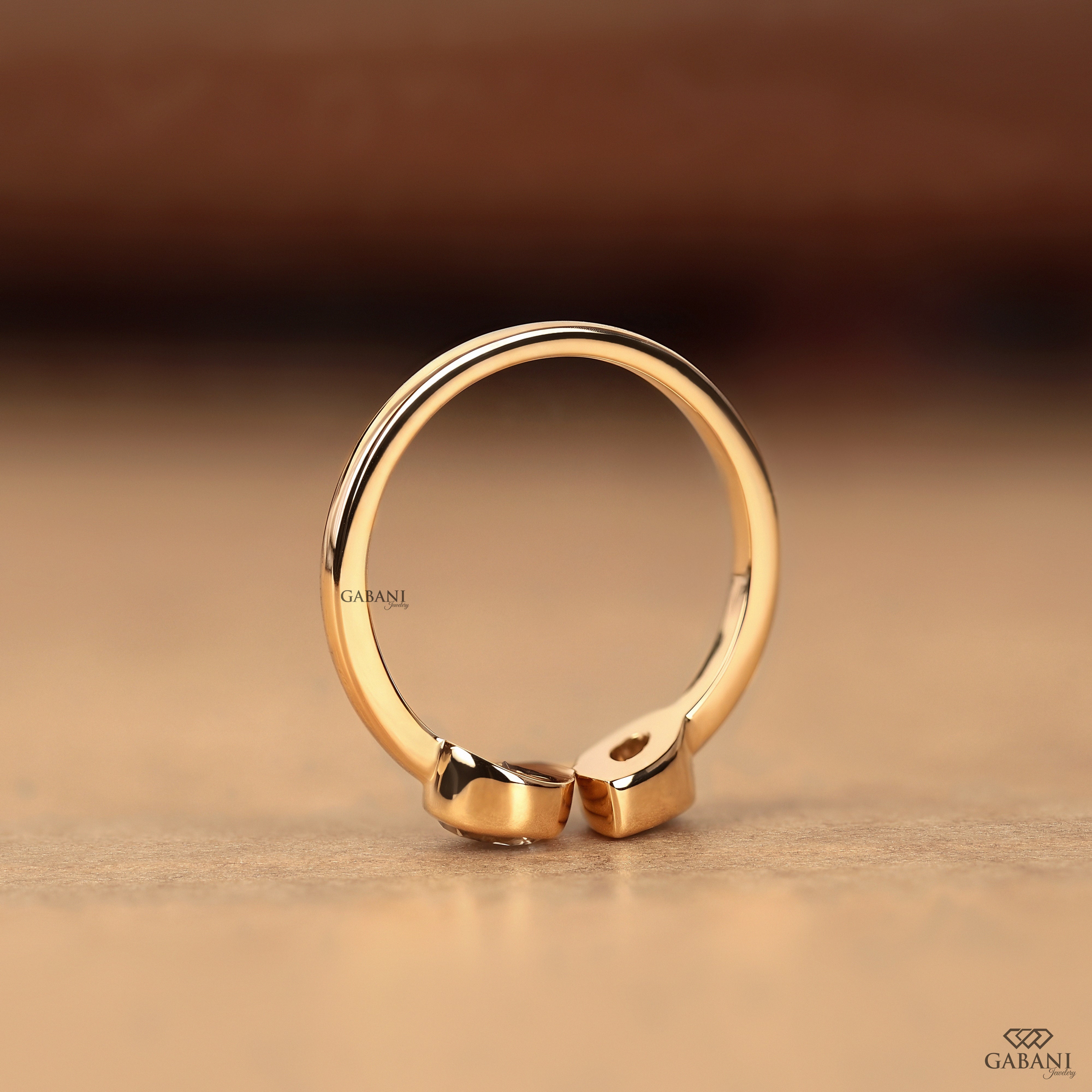Standing view of a pear cut lab grown diamond Toi et Moi engagement ring with matching bezel set diamonds