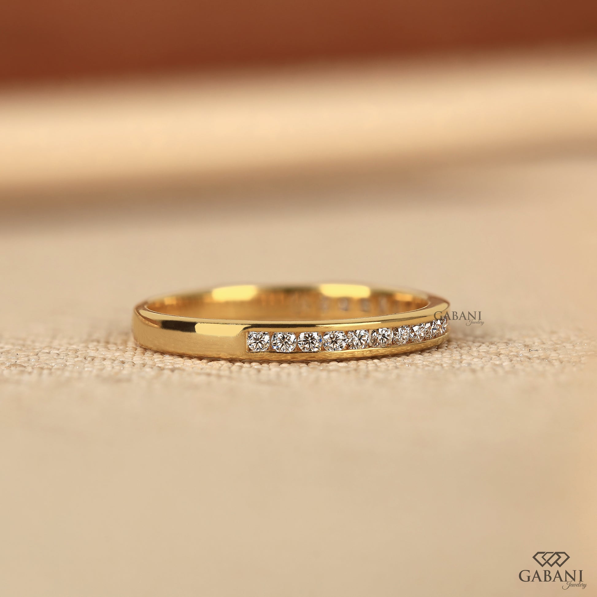 minimal yellow gold diamond band designed with a smooth channel setting