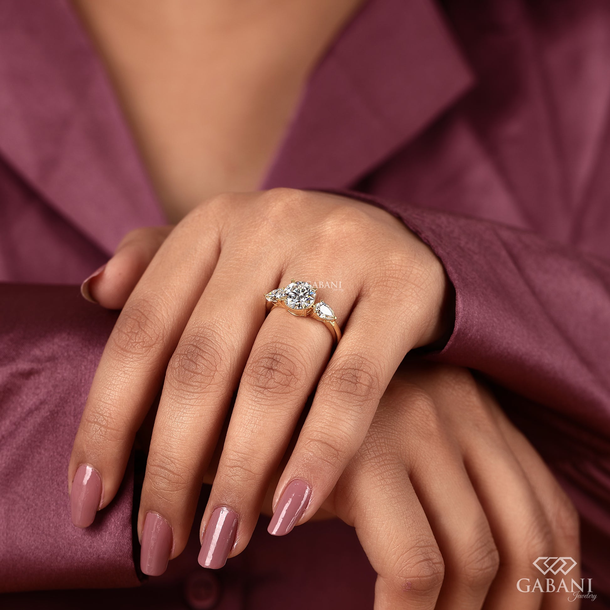 three stone engagement ring featuring round lab grown diamond and pear accents in yellow gold