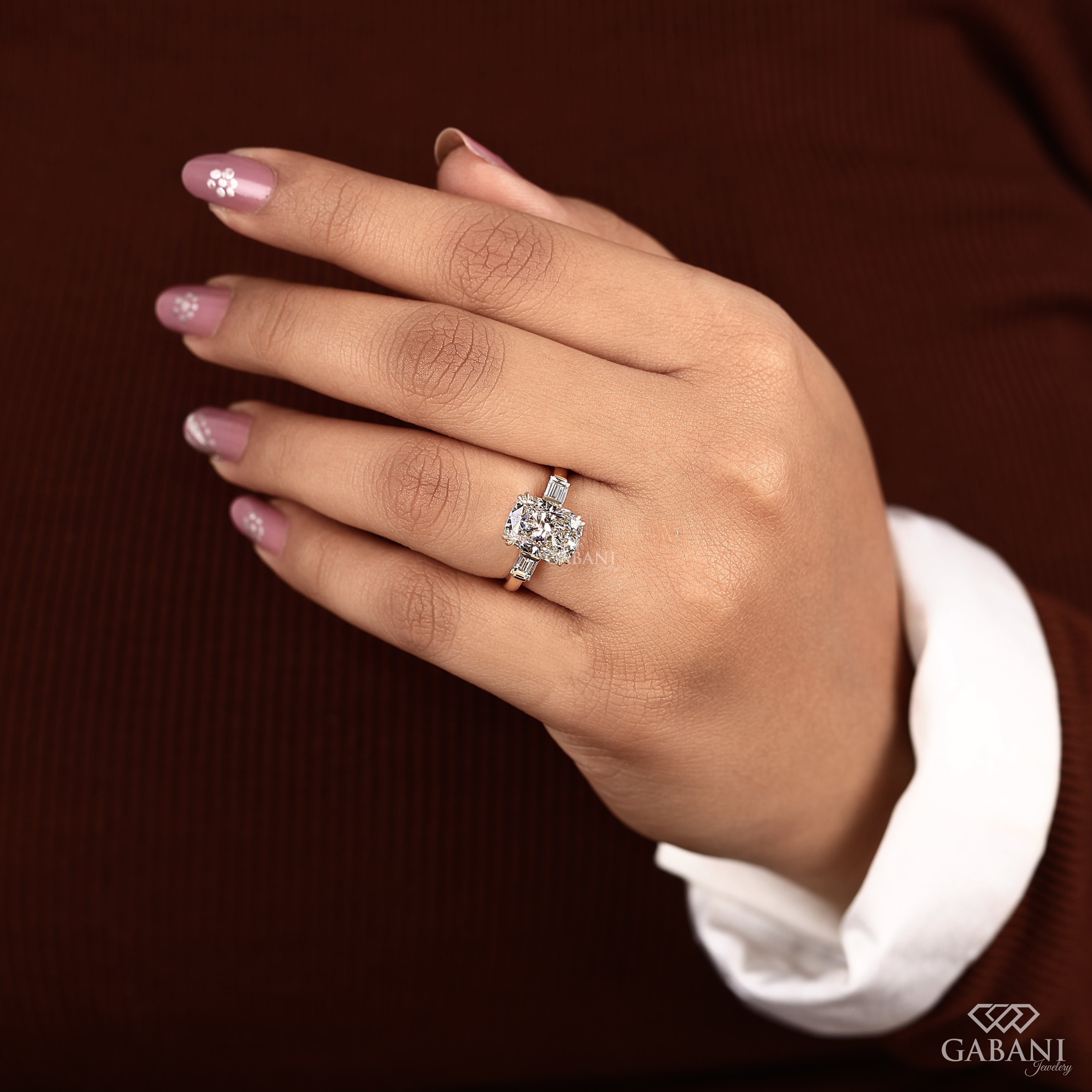 Cushion cut lab grown diamond three stone ring on model’s fingers