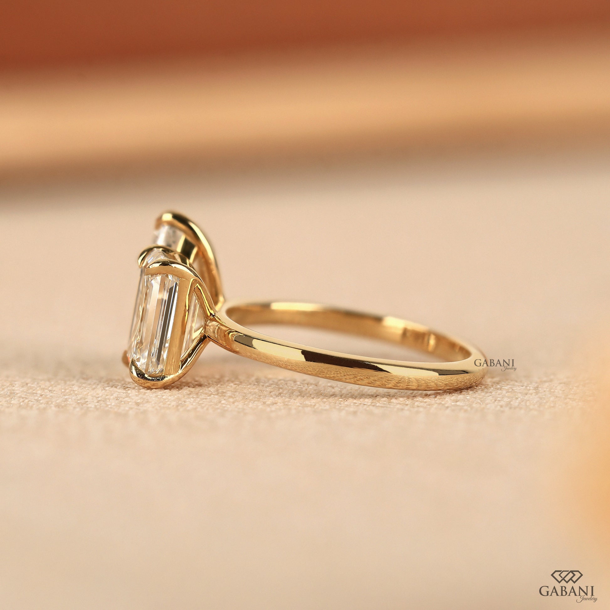 You and me ring with emerald cut and pear cut lab diamonds crafted in solid yellow gold