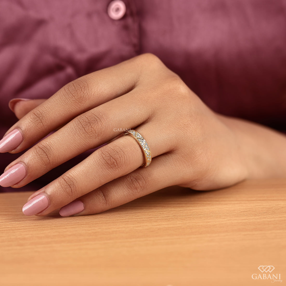 Round lab grown diamond wedding band with geometric triangular pattern and polished yellow gold setting.