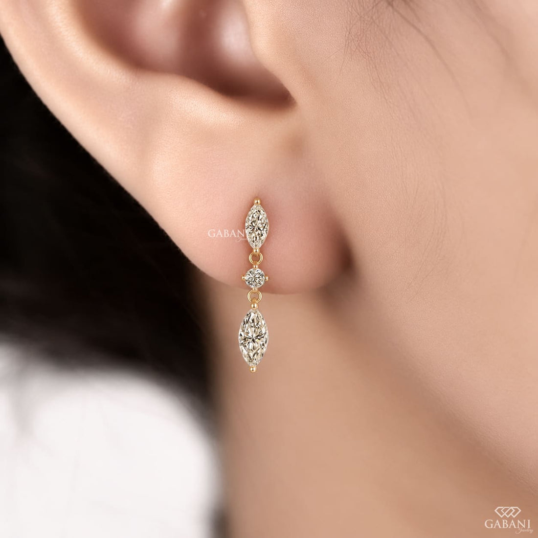 marquise and round cut lab grown diamond drop earrings in yellow gold, featuring two sparkling marquise diamonds connected by a round brilliant diamond on each earring, creating an elegant three-stone design by Gabani Jewelry.
