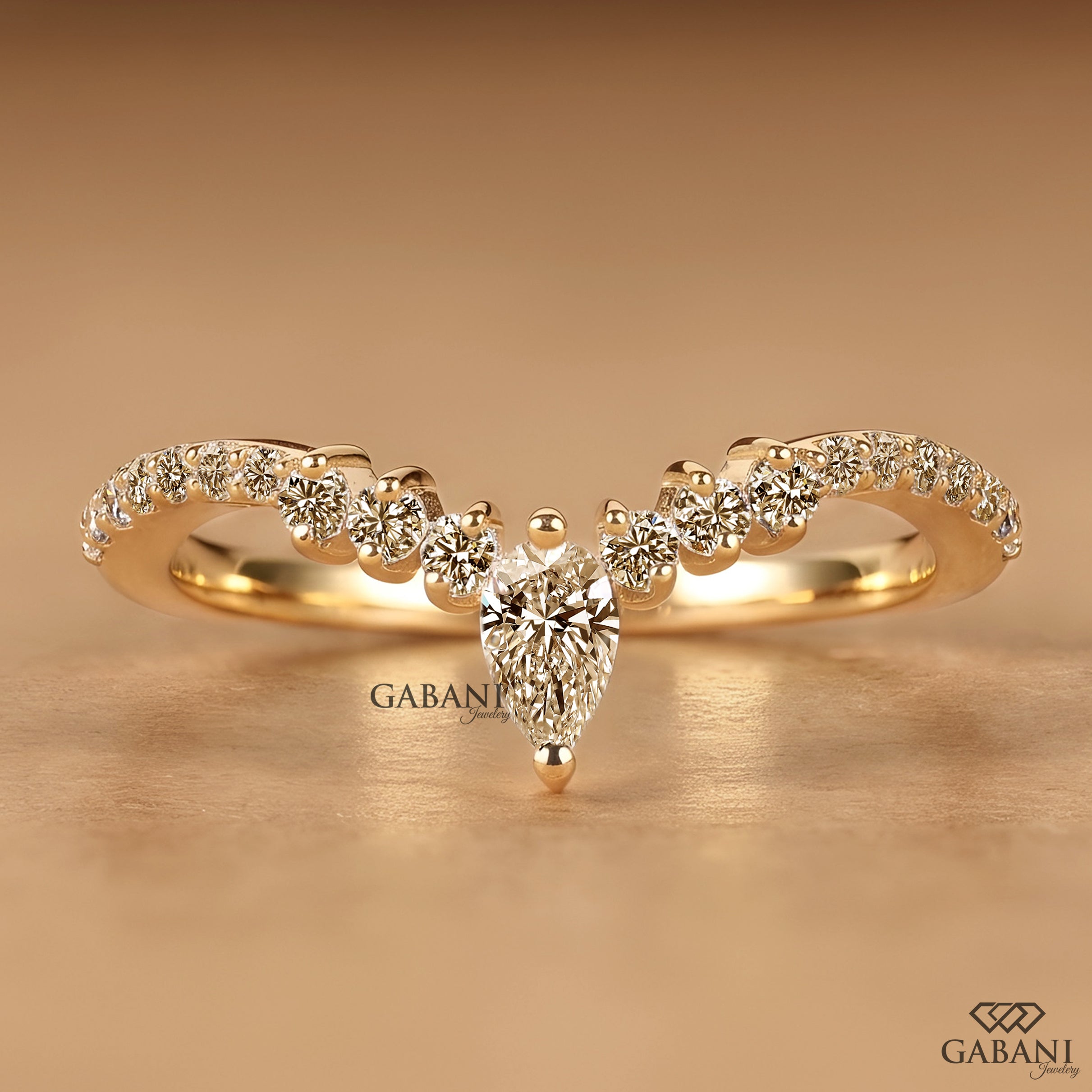 Front view of Gabani Jewelry V shaped chevron wedding band with pear cut lab grown diamond in solid gold