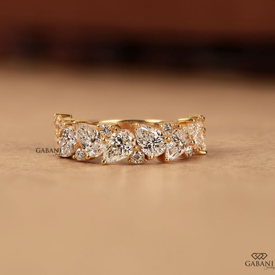 Pear and round lab grown diamond half eternity wedding band in yellow gold with alternating prong set diamond design.