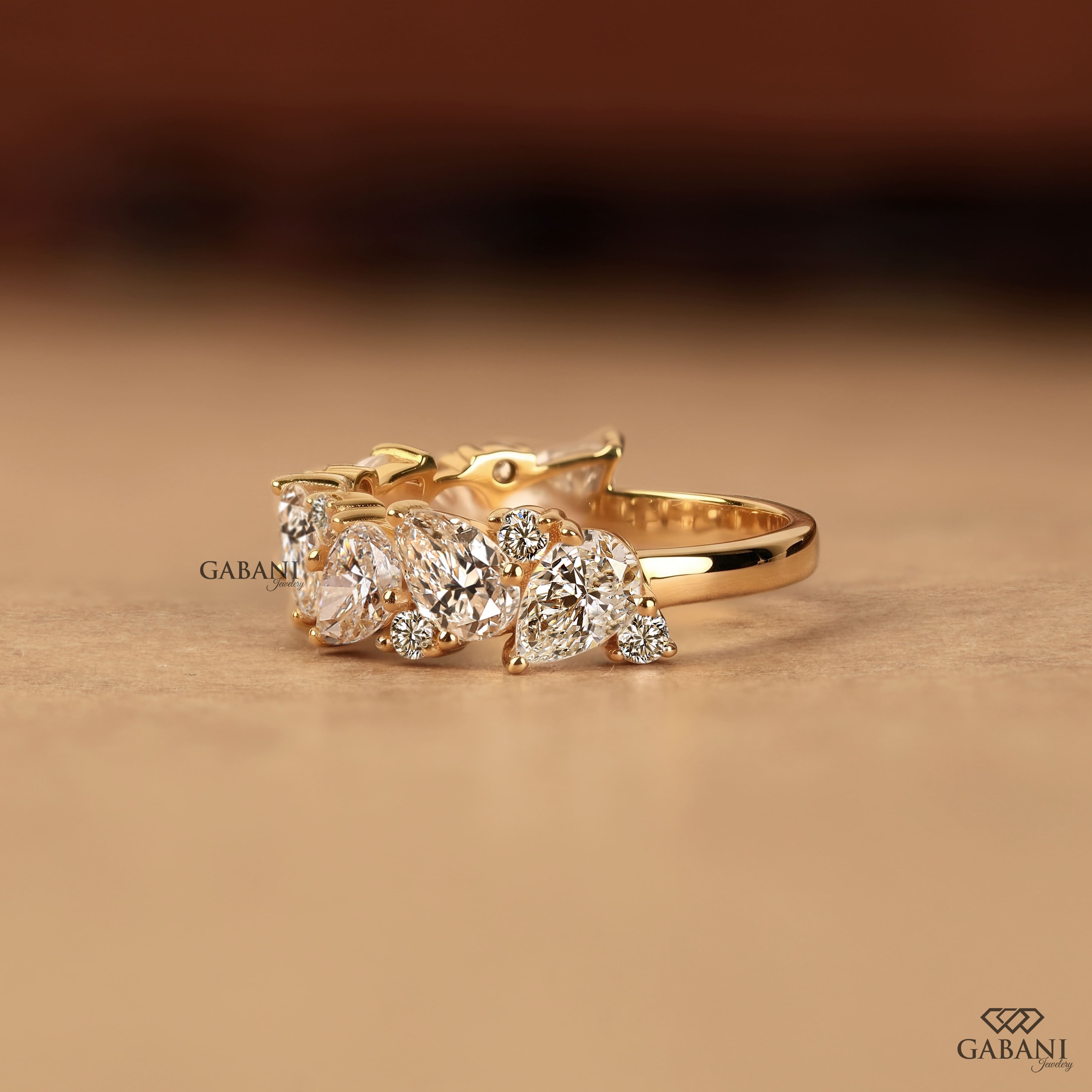 Pear and round lab grown diamond half eternity wedding band in yellow gold with alternating prong set diamond design.