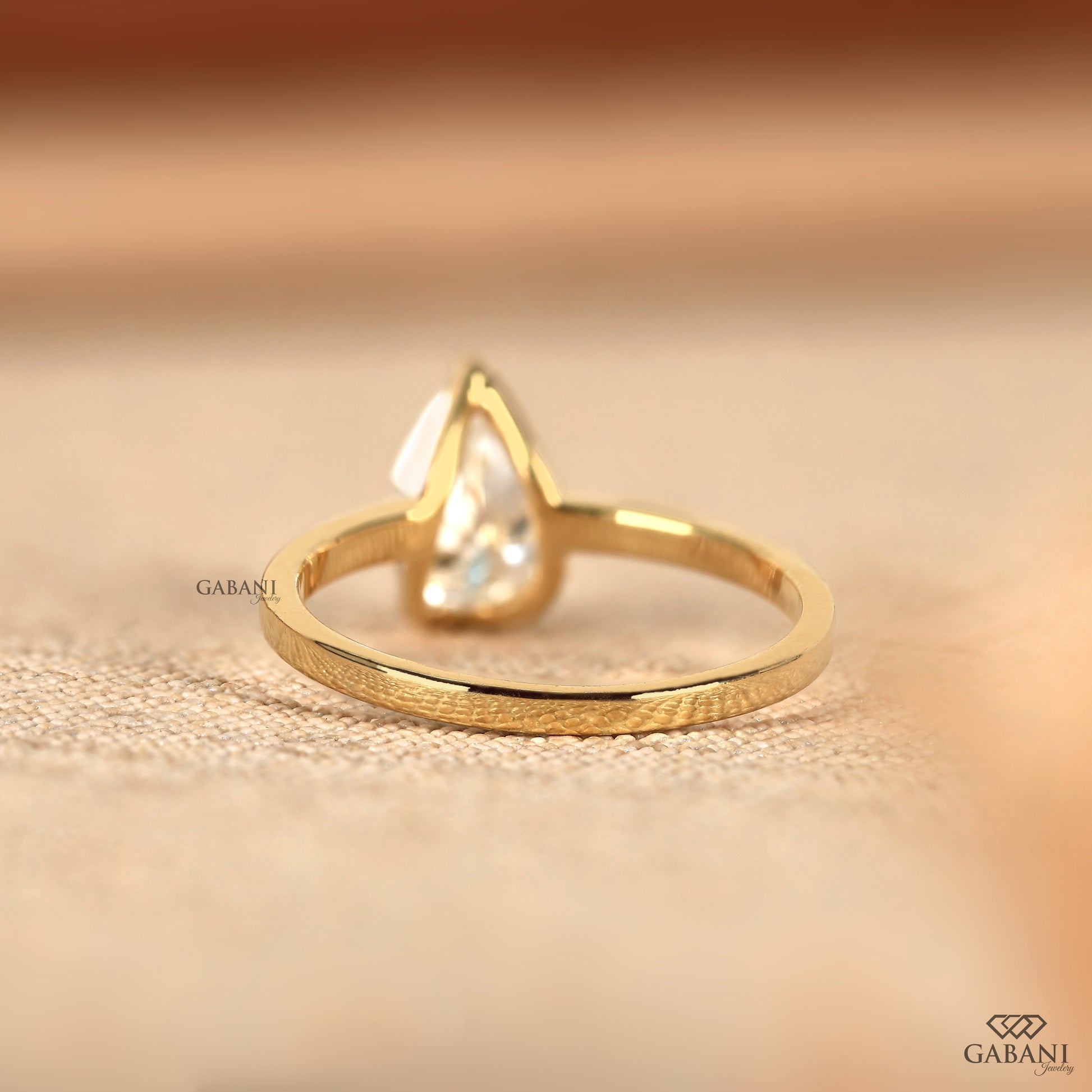Half bezel pear lab grown diamond proposal ring in yellow gold
